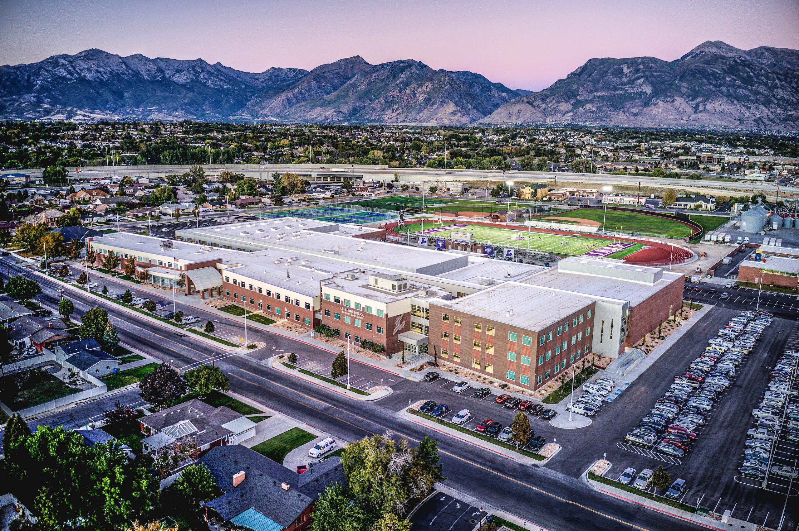 Three people sitting on a couch in a room looking at mobile devices