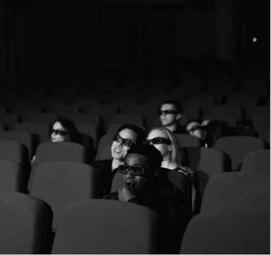 Espectadores sentados en una sala de cine, representando las campañas promocionales de spots y product placement en películas.
