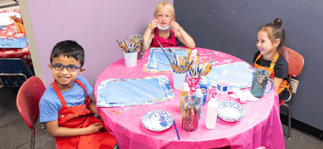 Three art class students painting