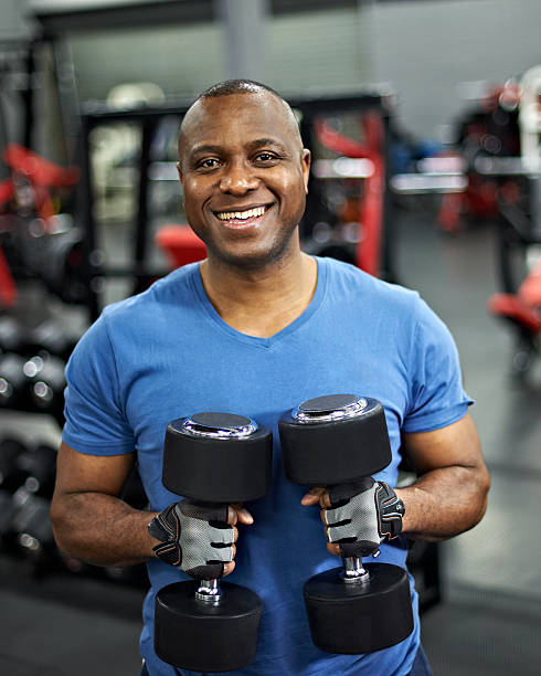 an image of a man holding two dumbbells