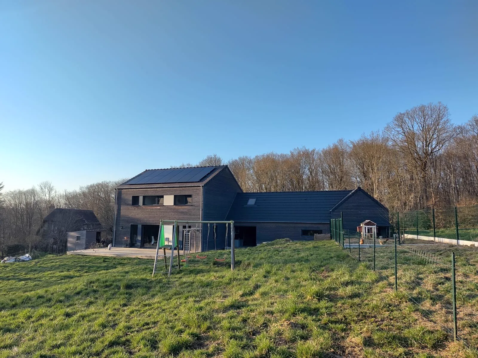 Photo d'une maison à Les Hogues équipée de panneaux photovoltaïques et d'une batterie physique dont l'installation a été faite par Solarock.