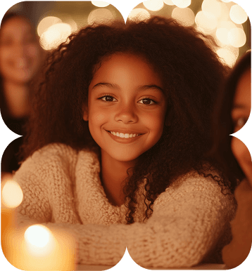 a gird with curly hair candles in her front smiling facing front