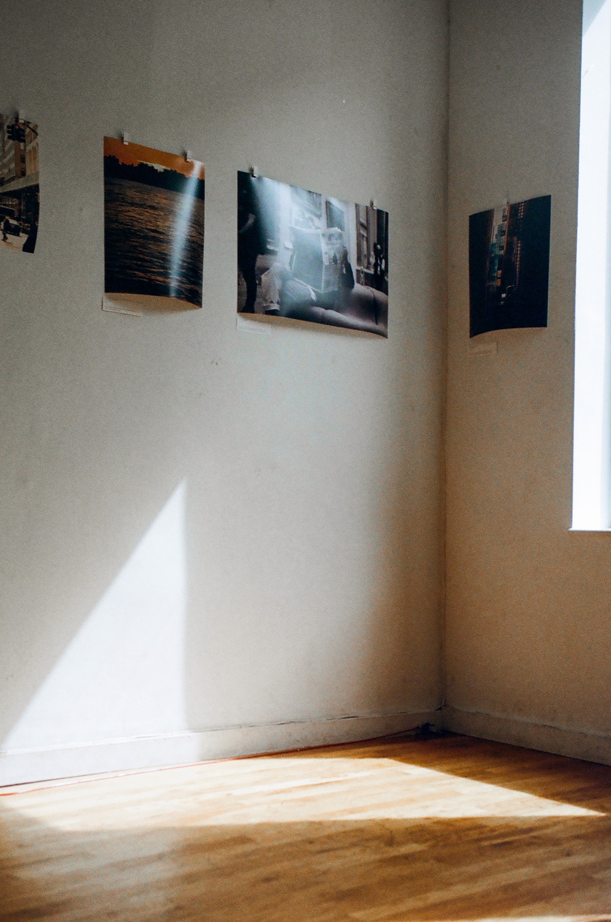 Sunlight hitting a corner of the gallery with framed prints hung along the walls.