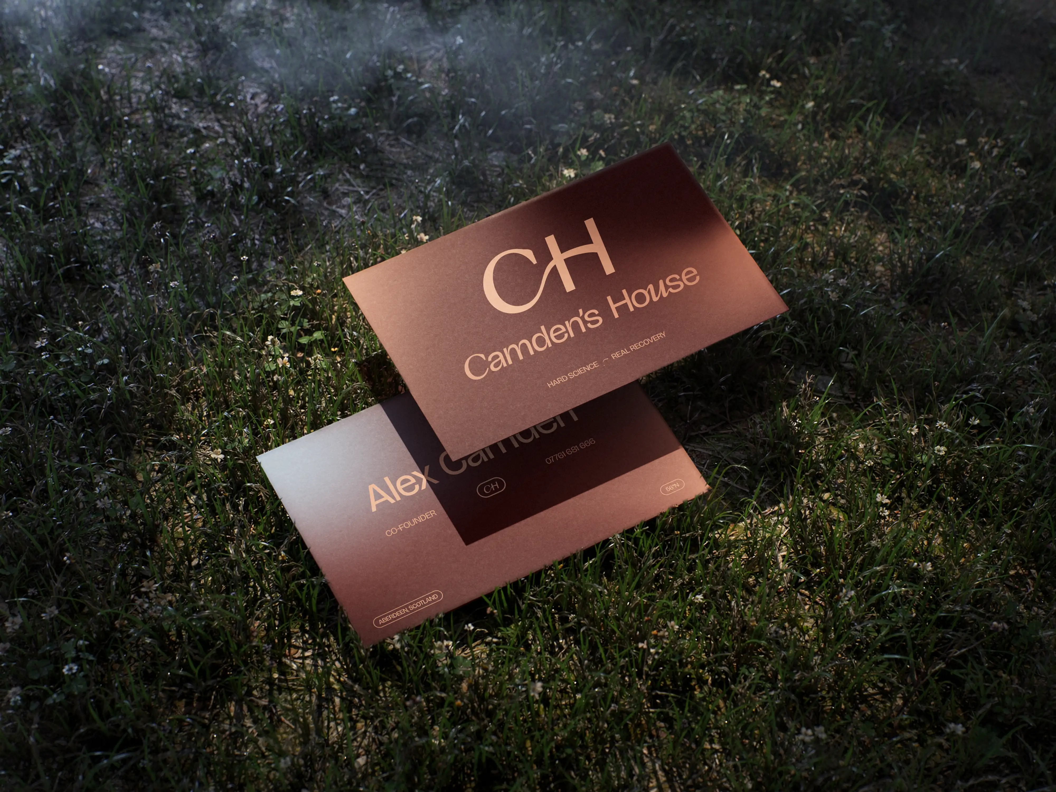 Camden's House brand identity — business card design with CH monogram logo photographed on grass