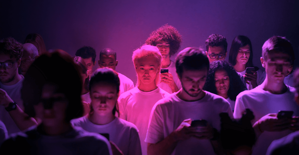 a guy, lost in a crowd of people looking at their phones