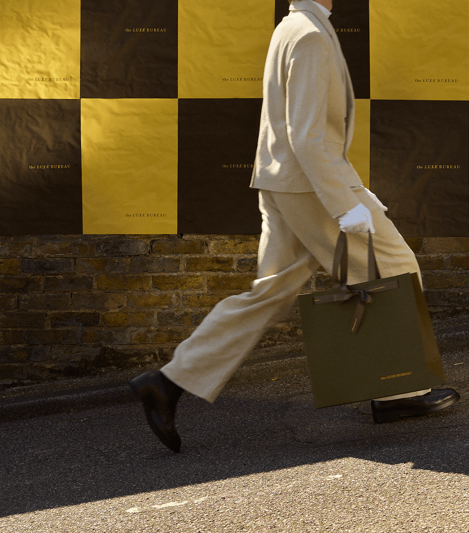 model walking past branded the luxe bureau posters on the street