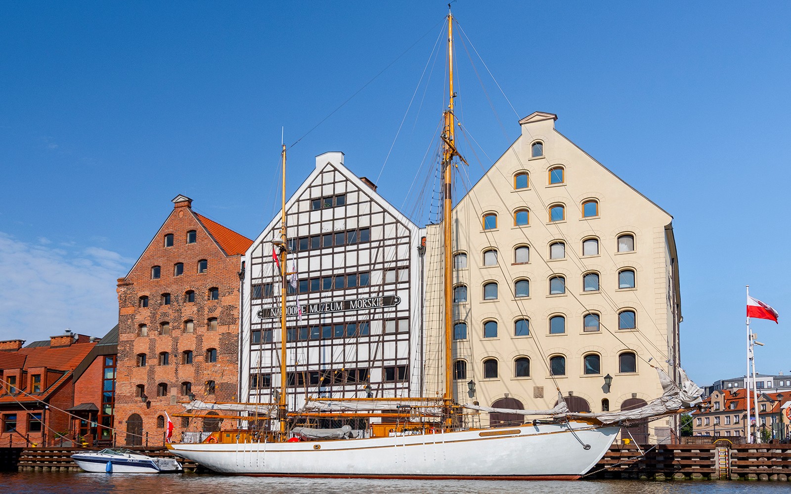 Gdansk Maritime Museum with sailboat on Motlawa River.