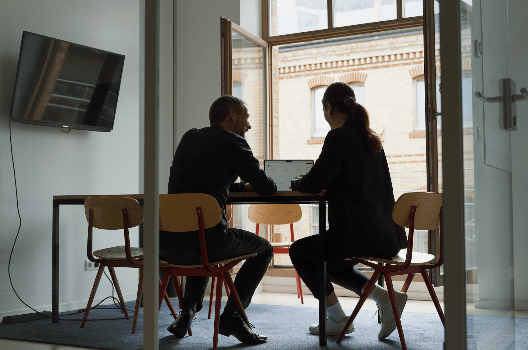 people sitting together at a table with laptops open