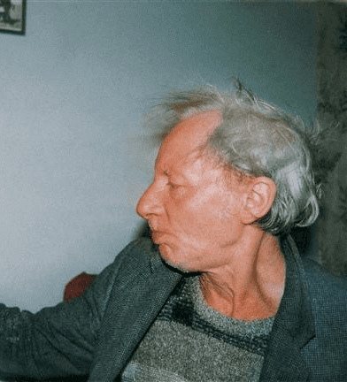Elderly man pouring a drink indoors