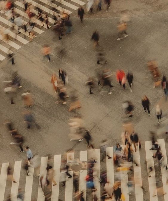 Vue aérienne floue de personnes traversant un carrefour avec des passages piétons