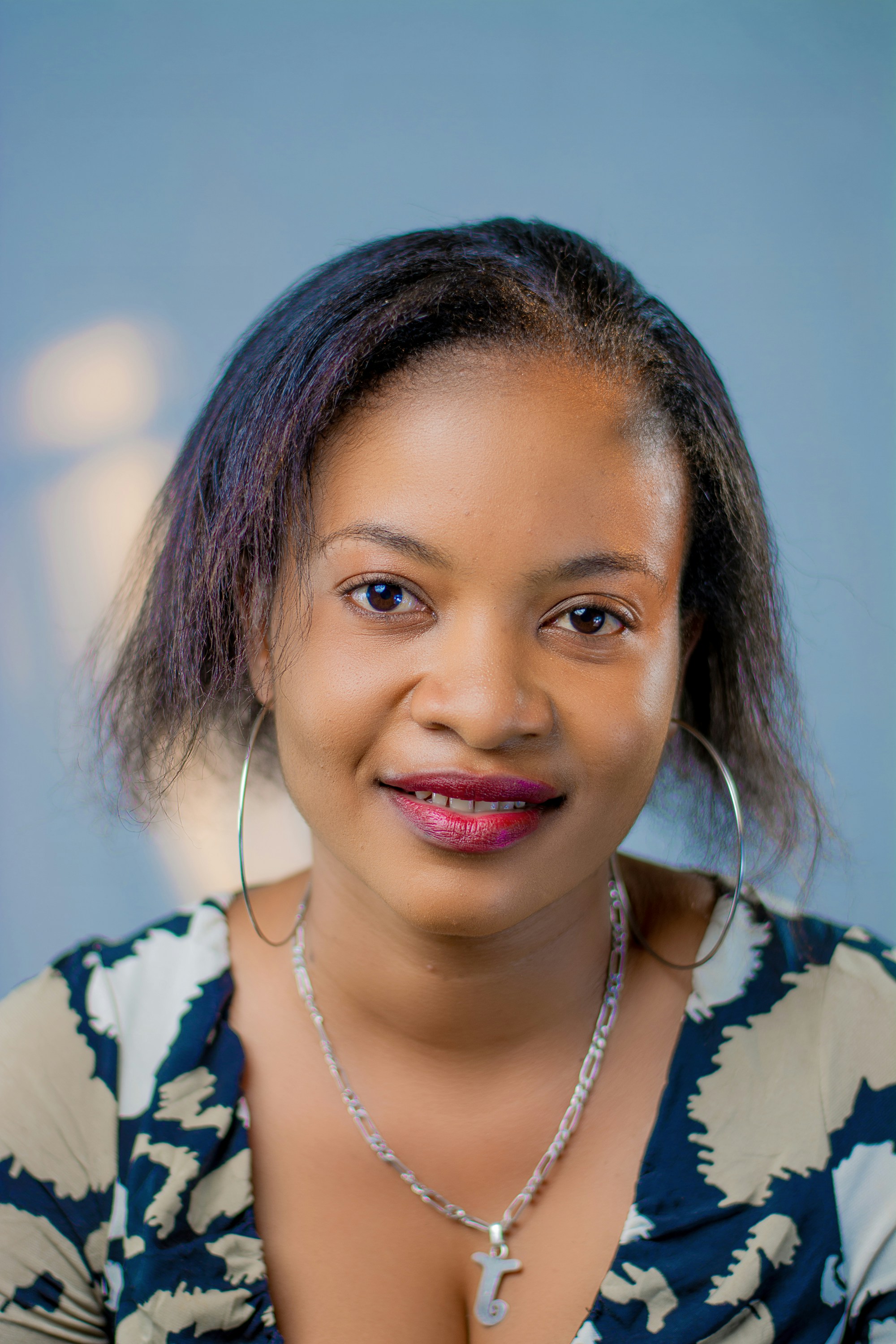 woman in white and blue floral shirt wearing silver necklace