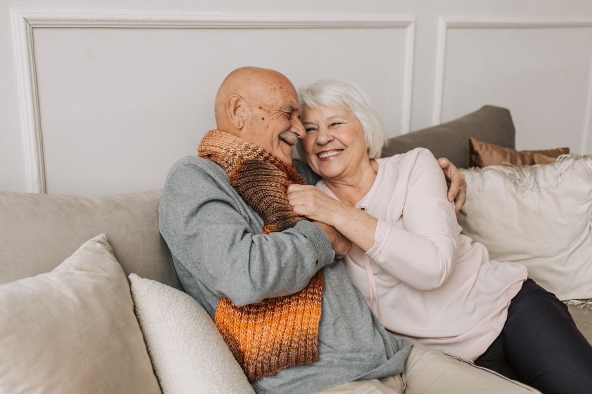 Senior couple enjoying a happy memory on the sofa.