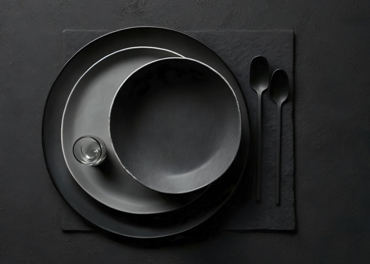 Warm-toned restaurant lounge with sculptural wooden ceiling panels, pendant lighting, caramel leather seating, and abstract wall art.