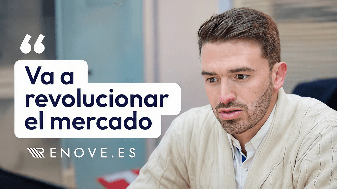 A man in an office, sitting comfortably on an orange chair, engaged in a task at his desk.