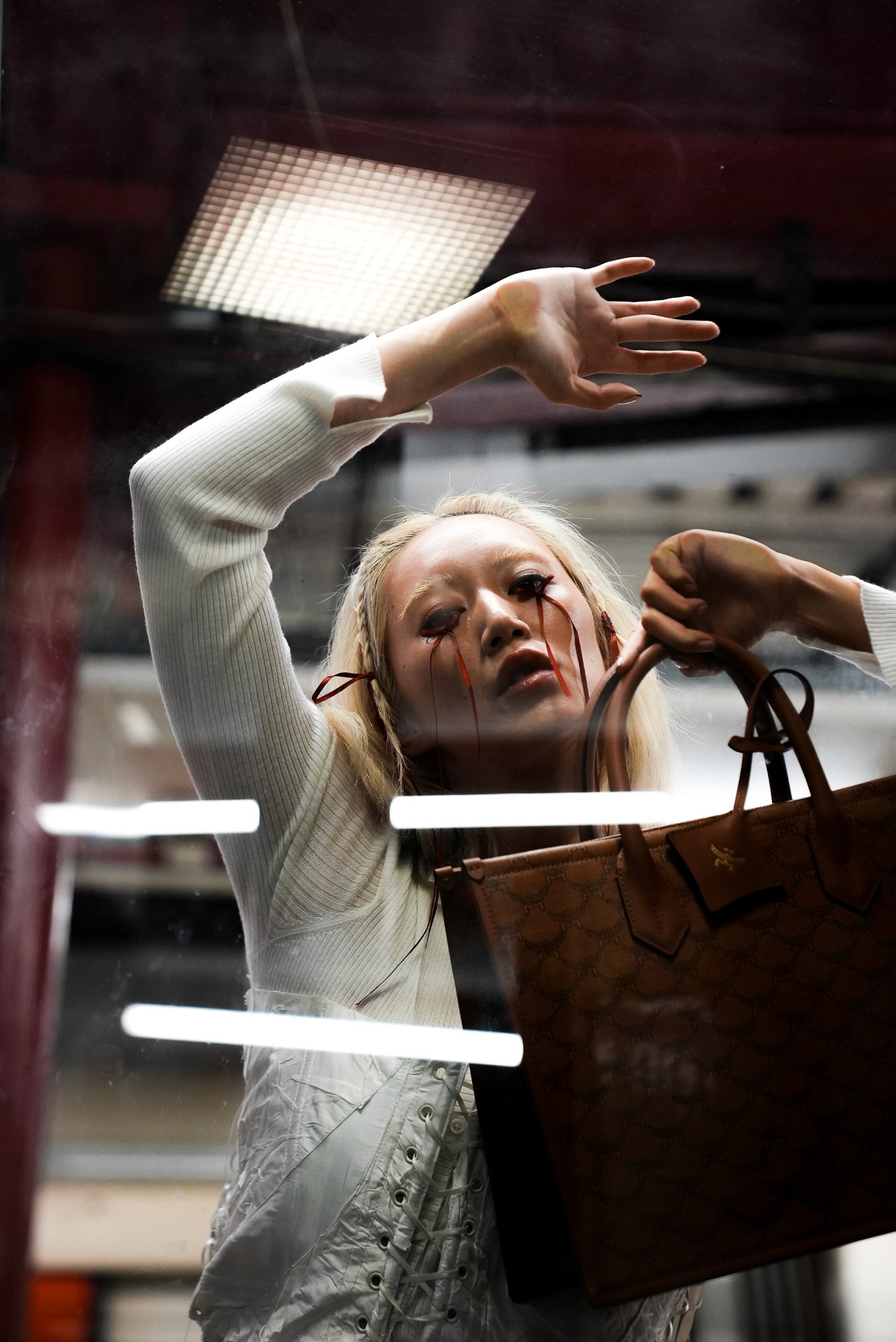 Woman hugging Shiba Inu dog in front of white fence
