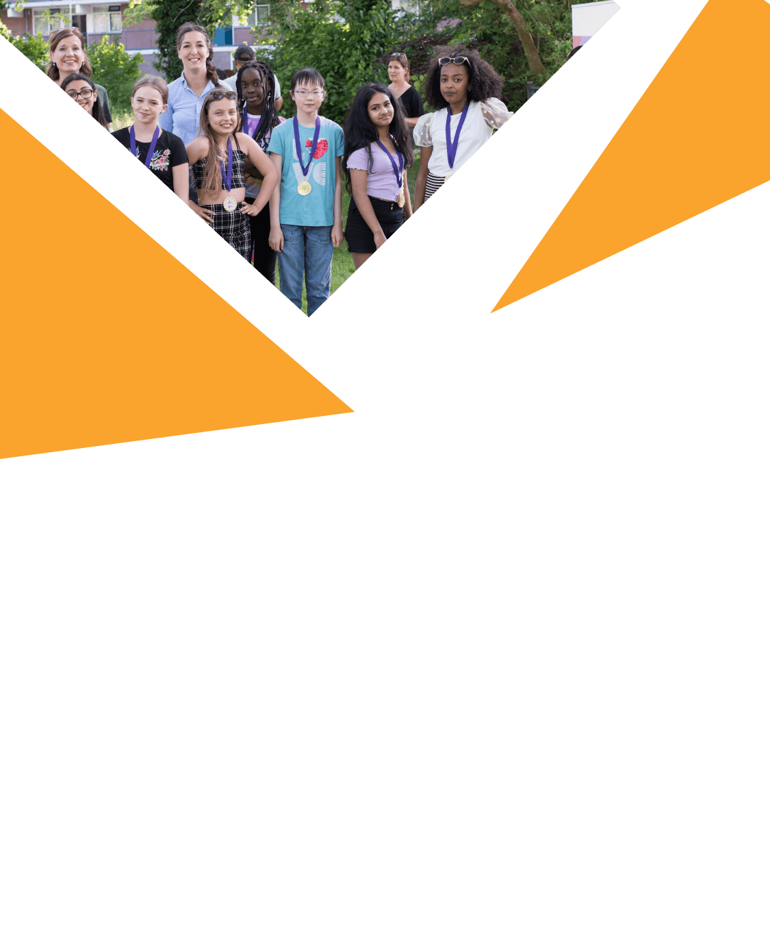 Groep kinderen met medailles poseert samen met begeleiders buiten in het gras