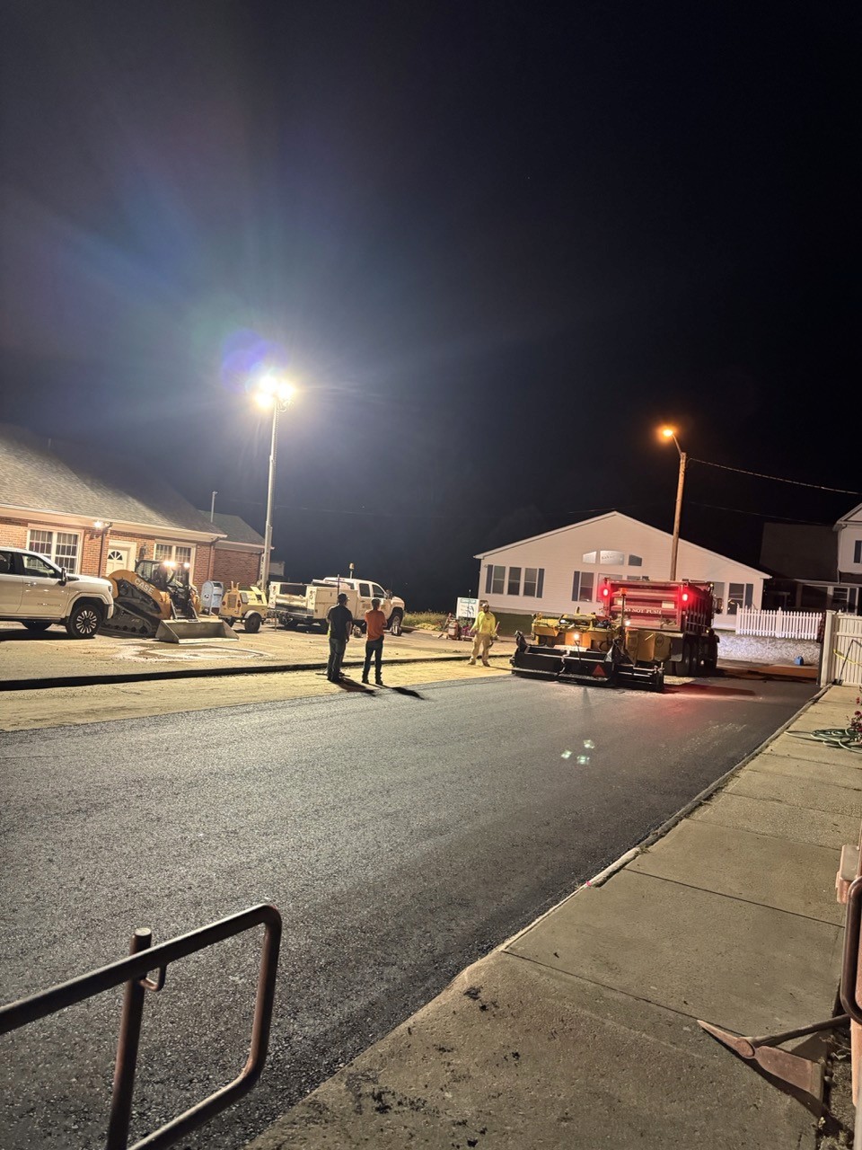 Asphalt paving operation under jobsite lighting, A&M Construction jobsite