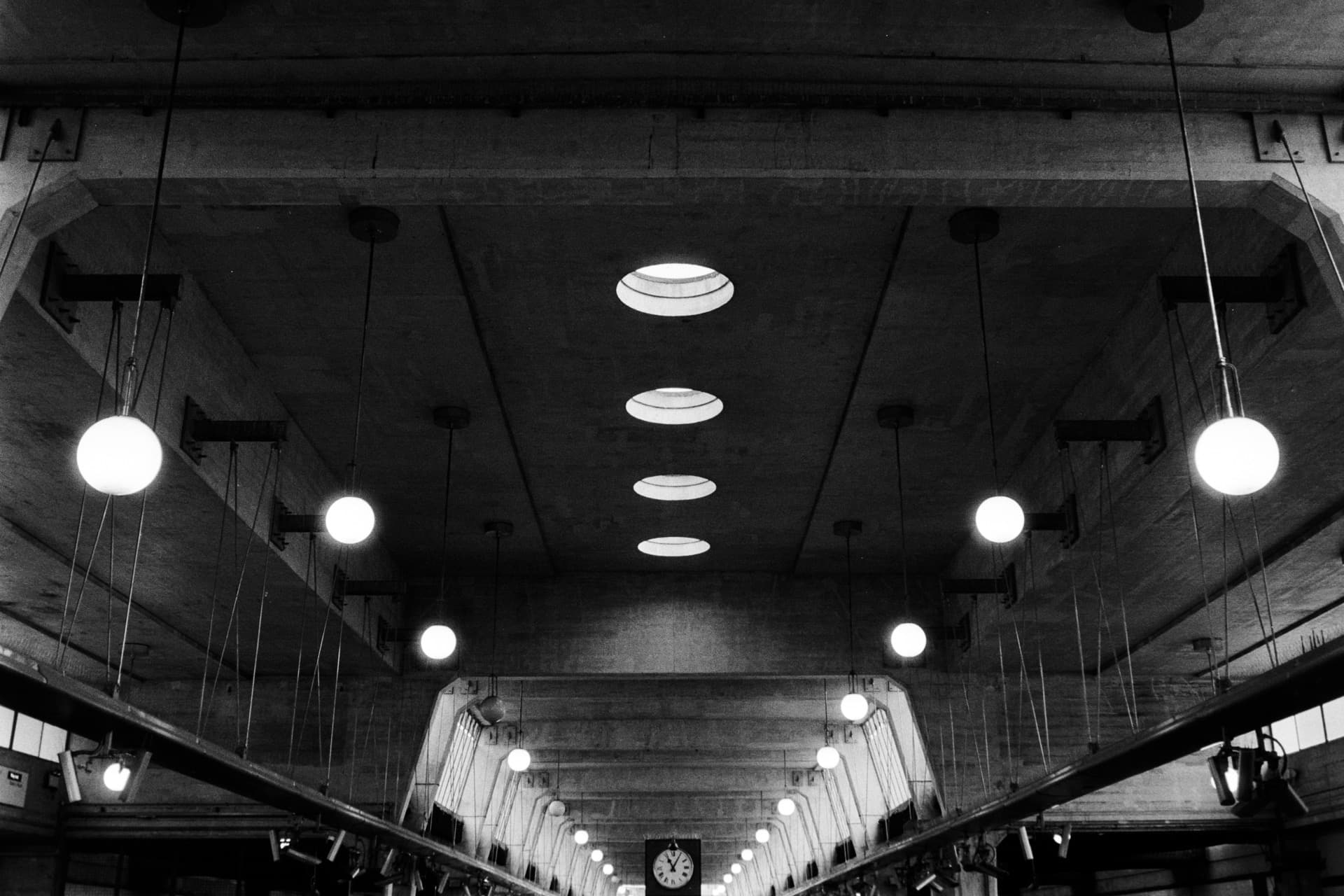 Symmetrical concrete ceiling with recessed lighting and escalators at Uxbridge Underground station