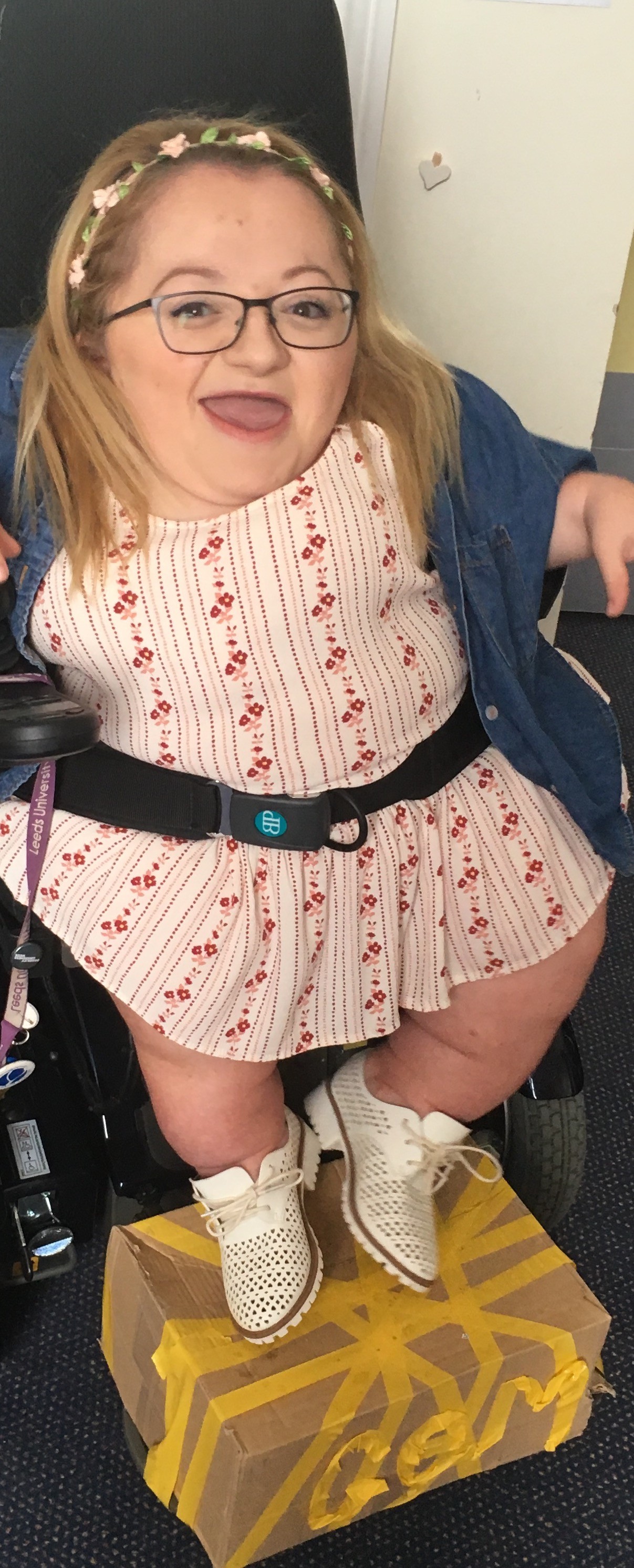 Gem in wheelchair with a cardboard box as footrest
