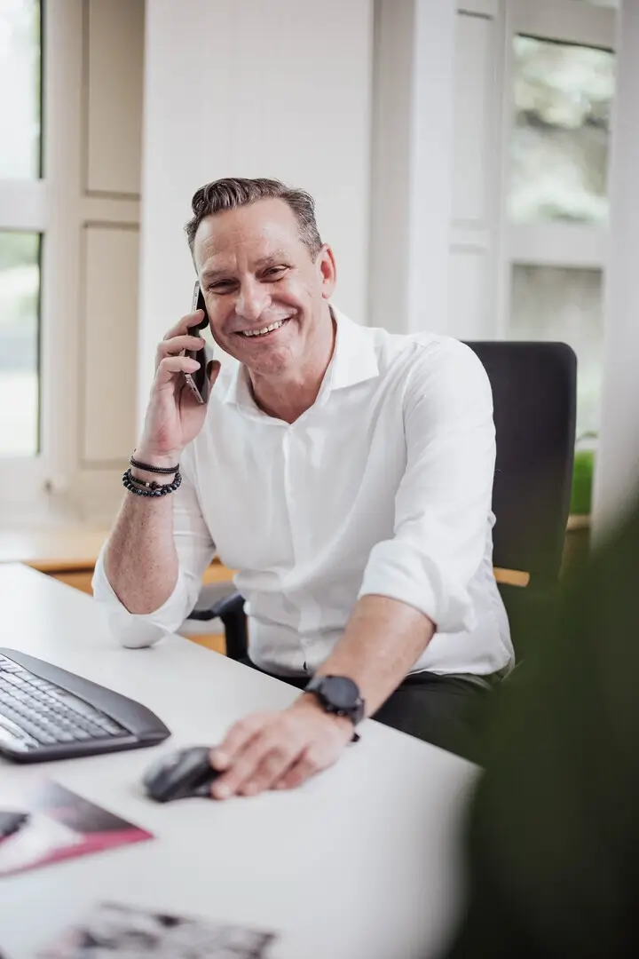 Professionelle Gastronomie- & Interieur-Fotografie: Gemütliche Lounge-Ecke mit rotem Sessel und beleuchteter Wein-Präsentation, inszeniert mit warmem Ambient-Licht und Fokus auf Design-Details.