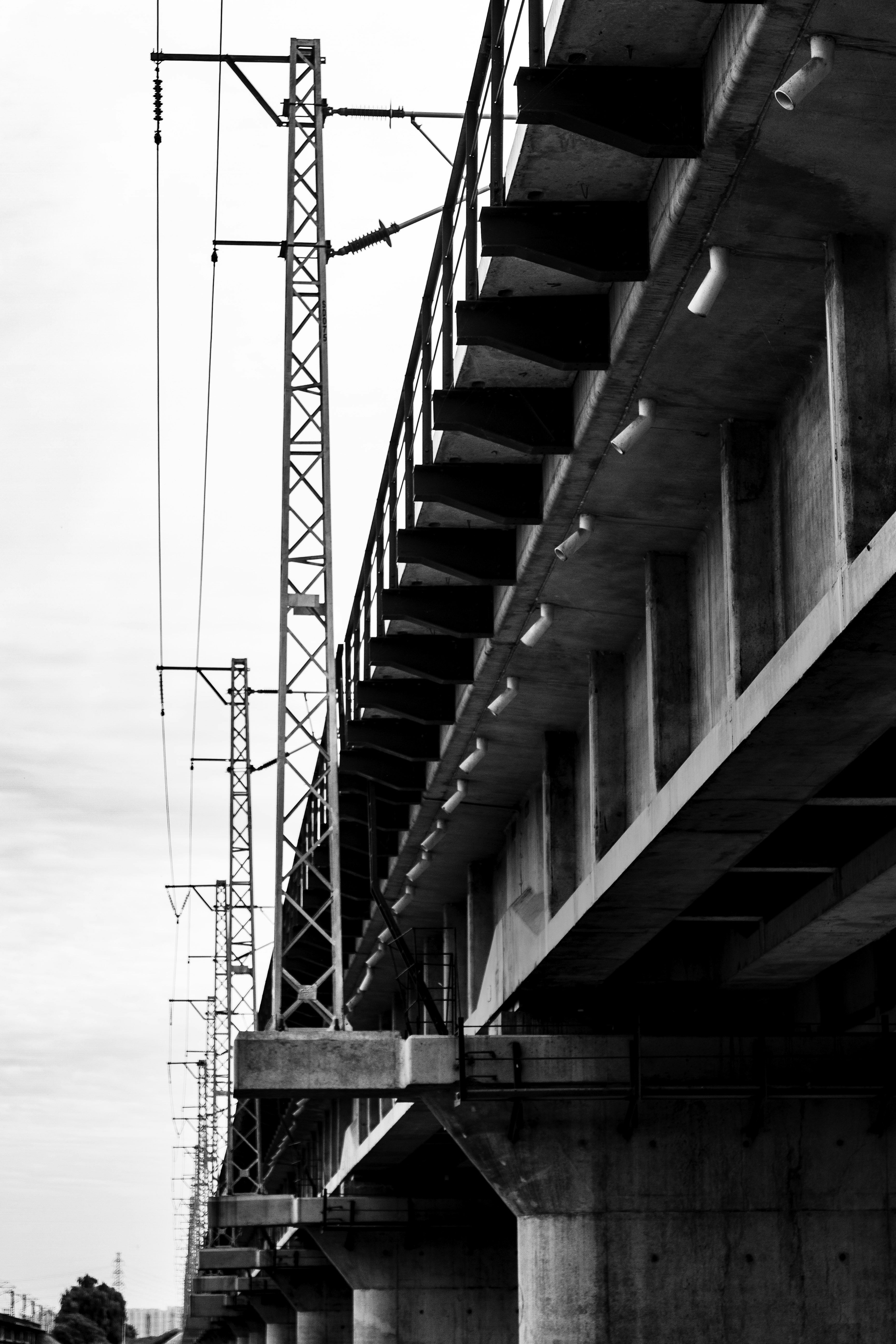Concrete bridge with overhead power lines and railway tracks
