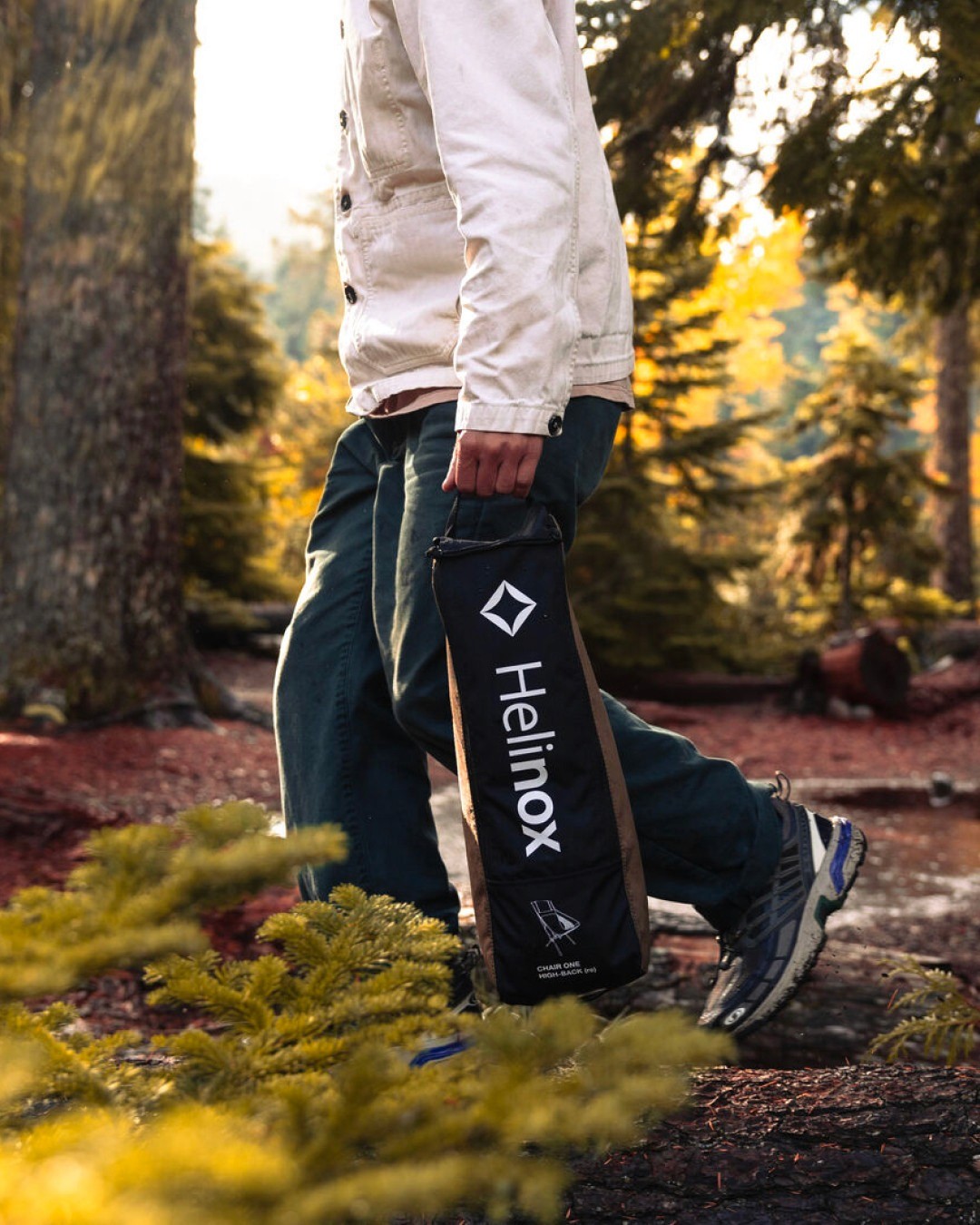 Un homme transporte un sac contenant du matériel pliant de camping Helinox