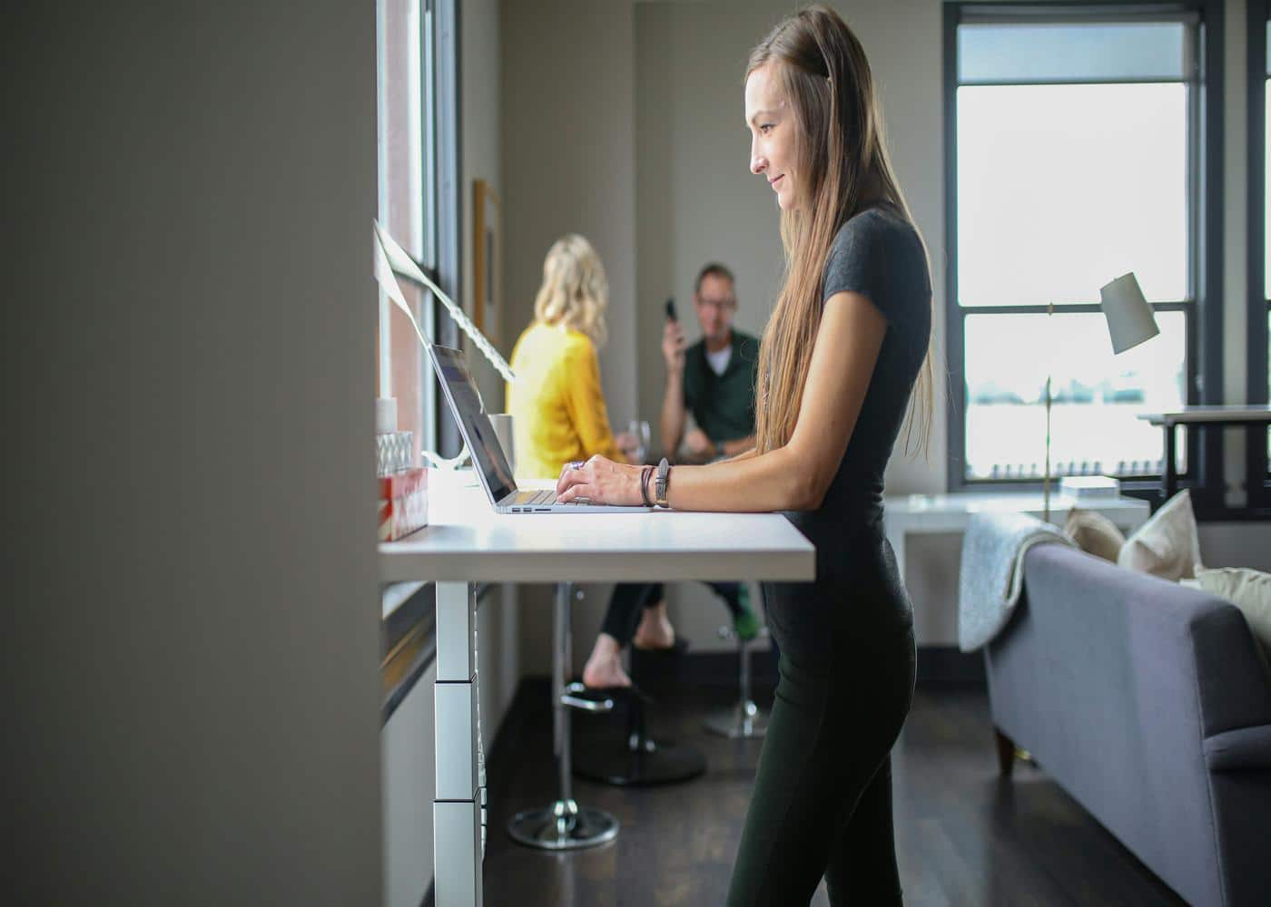 Woman practicing deskercise byworking on a standing desk