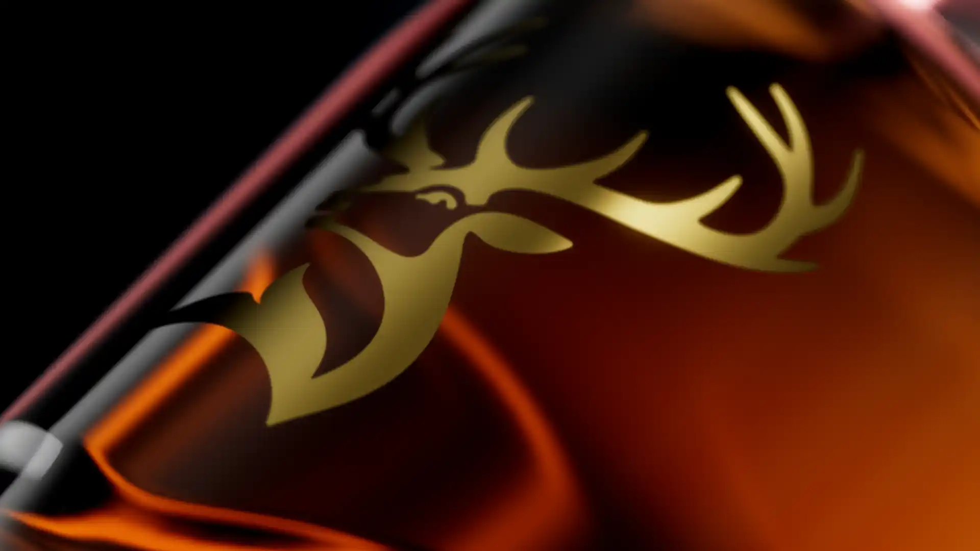Glenfiddich gold stag emblem on an amber whisky bottle, CGI close-up