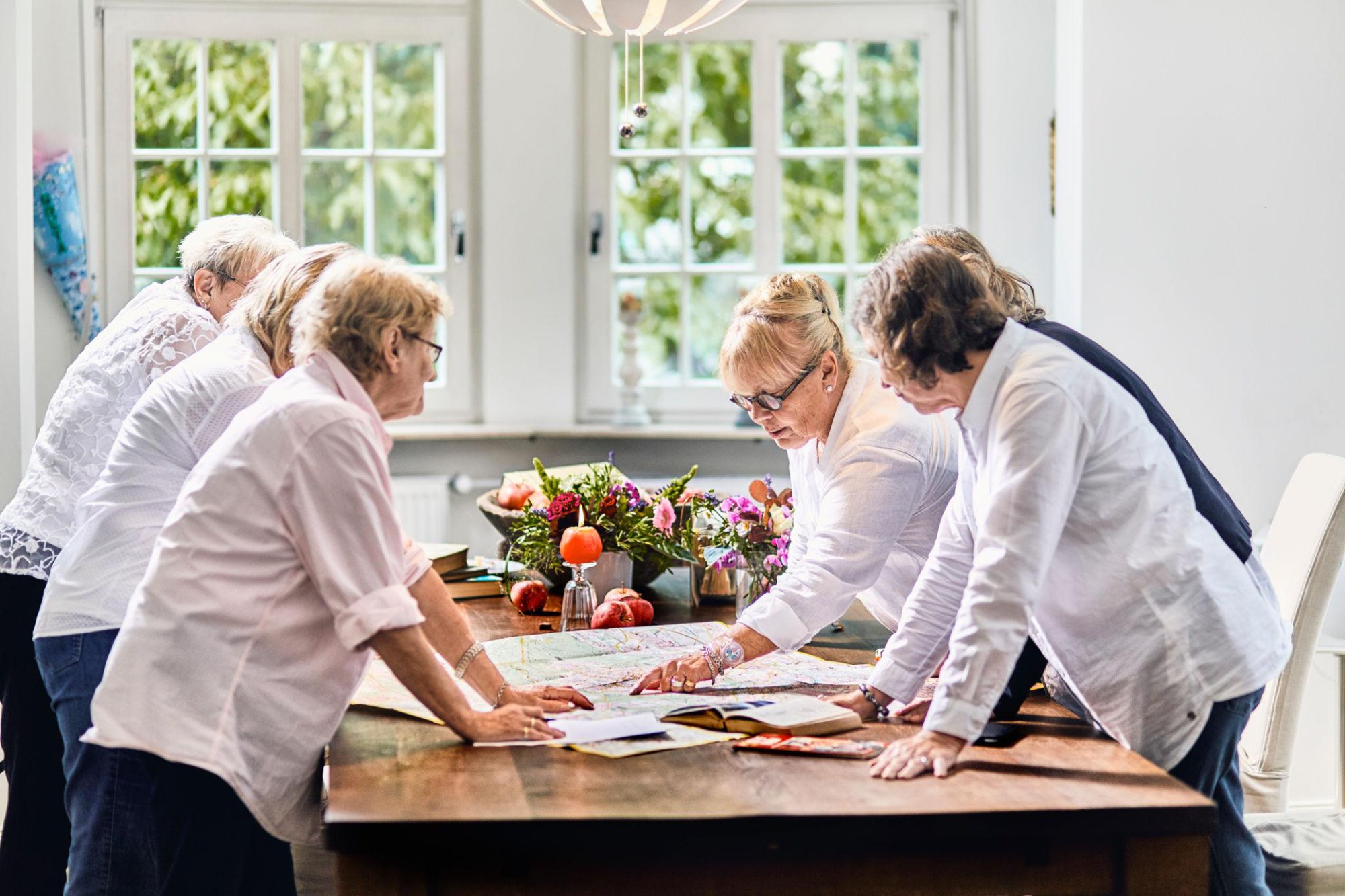 Women gathered around a table studying a map and planning together