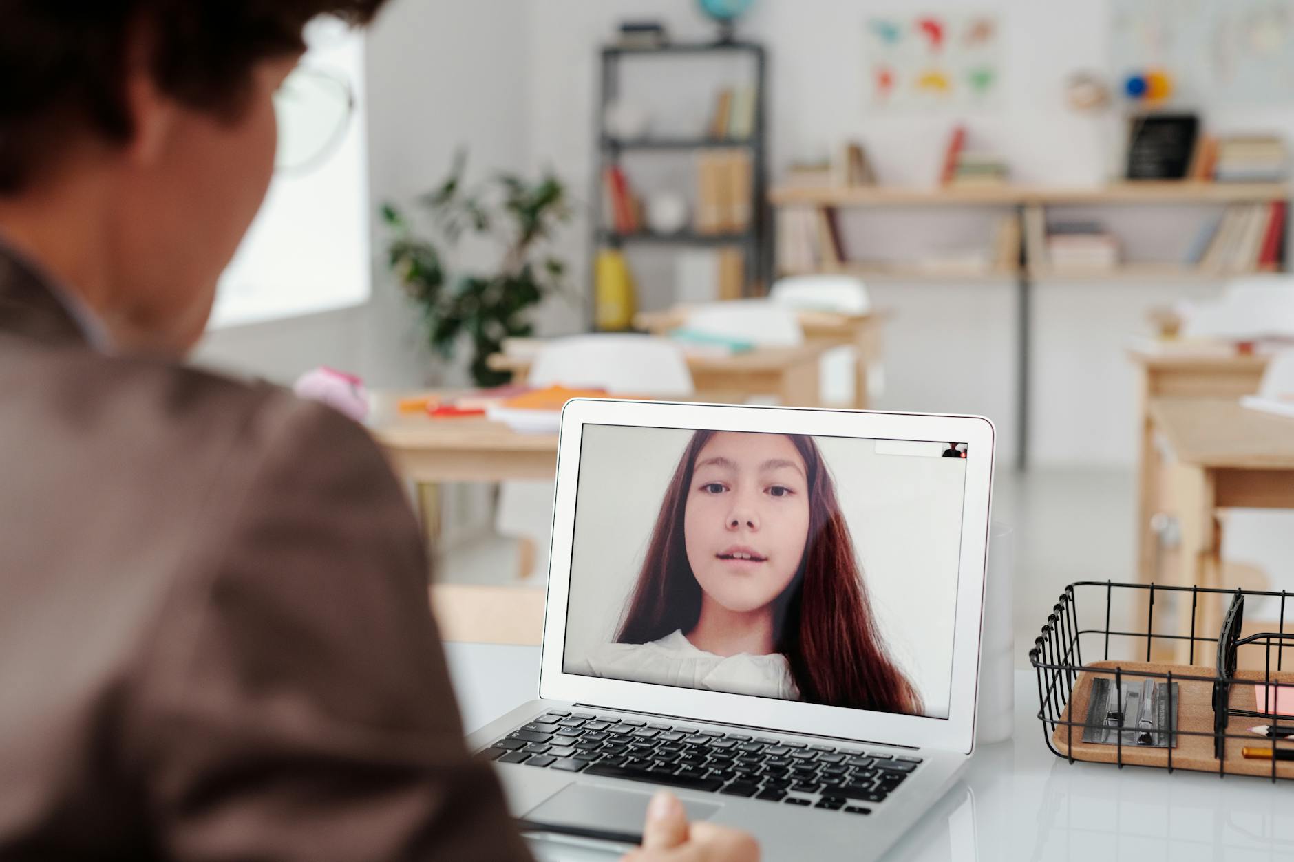 A close-up of a teacher sitting bedside a frustrated student to help overcome common student engagement barriers.