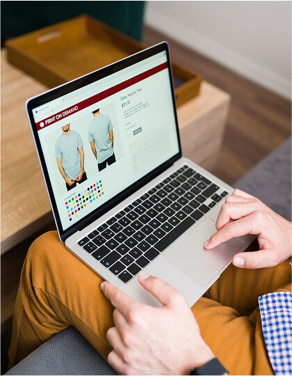 Hands on a laptop displaying an e-commerce website with colorful, showcasing online shopping.