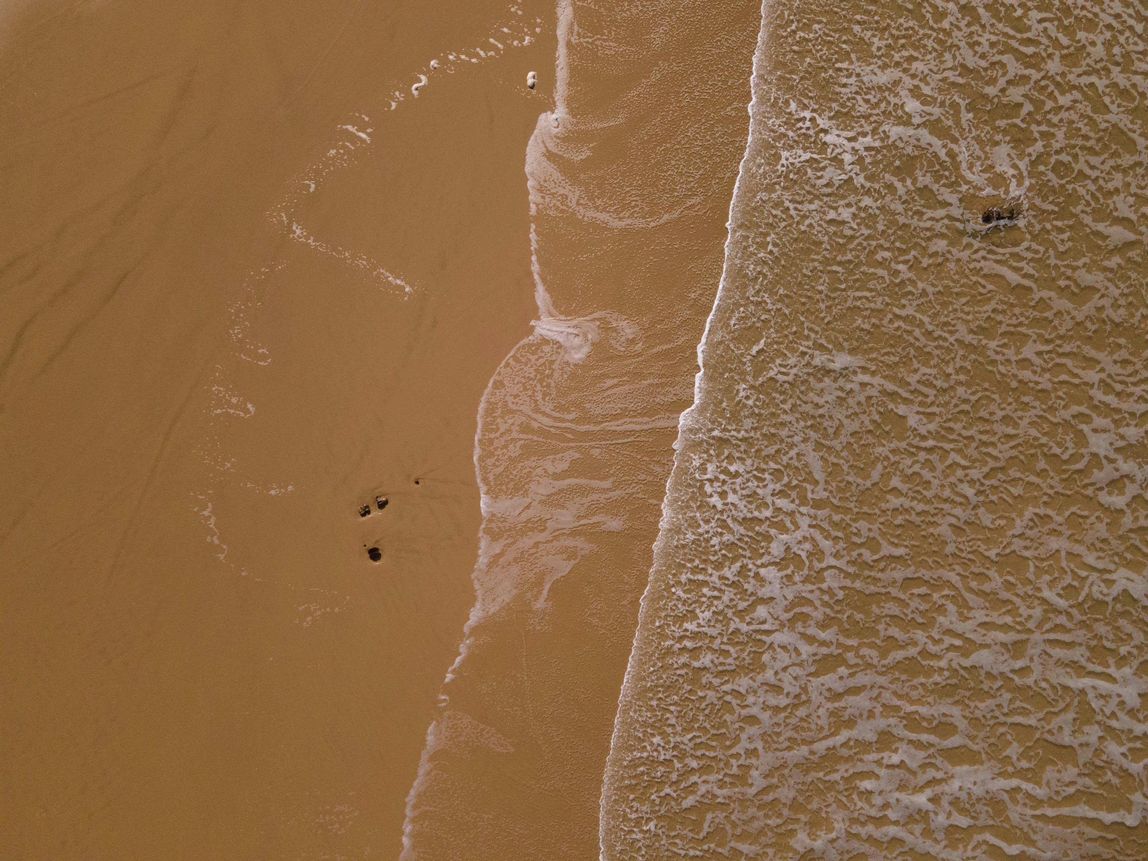 an aerial view of a sandy beach and ocean