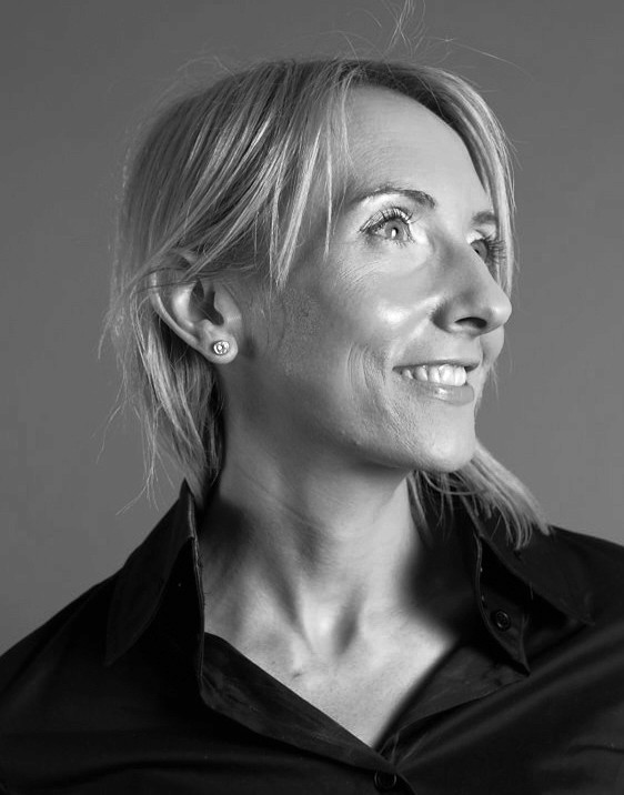 Woman working at desk with laptop and phone.