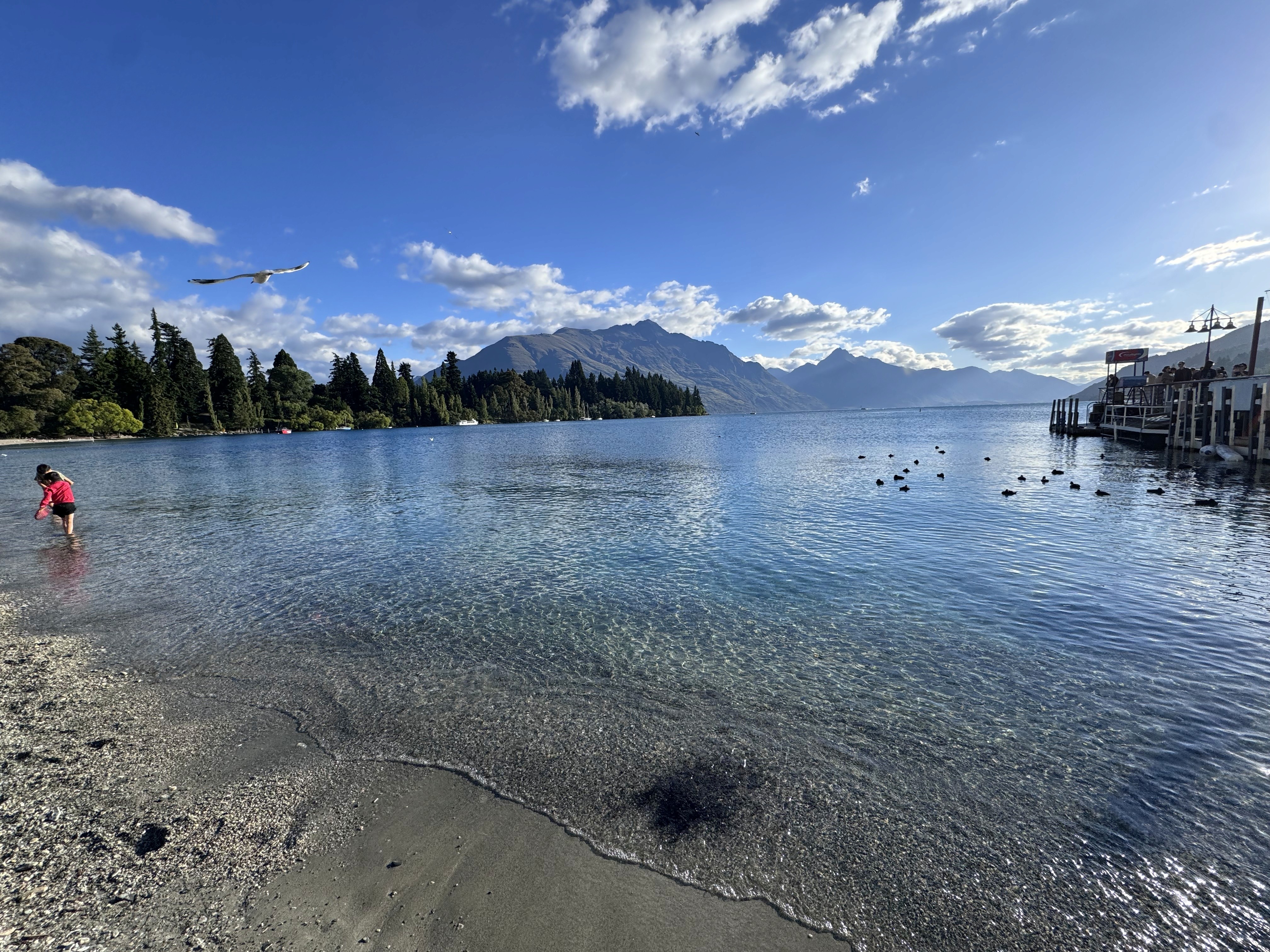 A young girl playing in the crystal clear waters of Lake Wakatipu in Queenstown