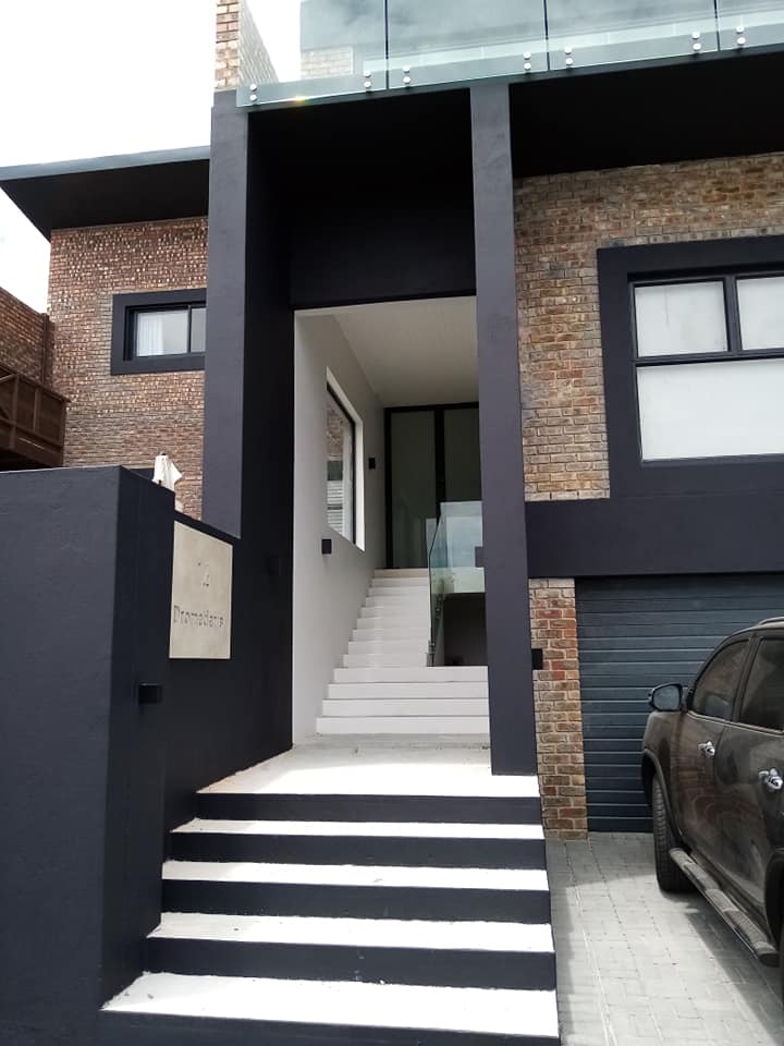 Two-storey mansion and entrance with staircase to tall glass front door