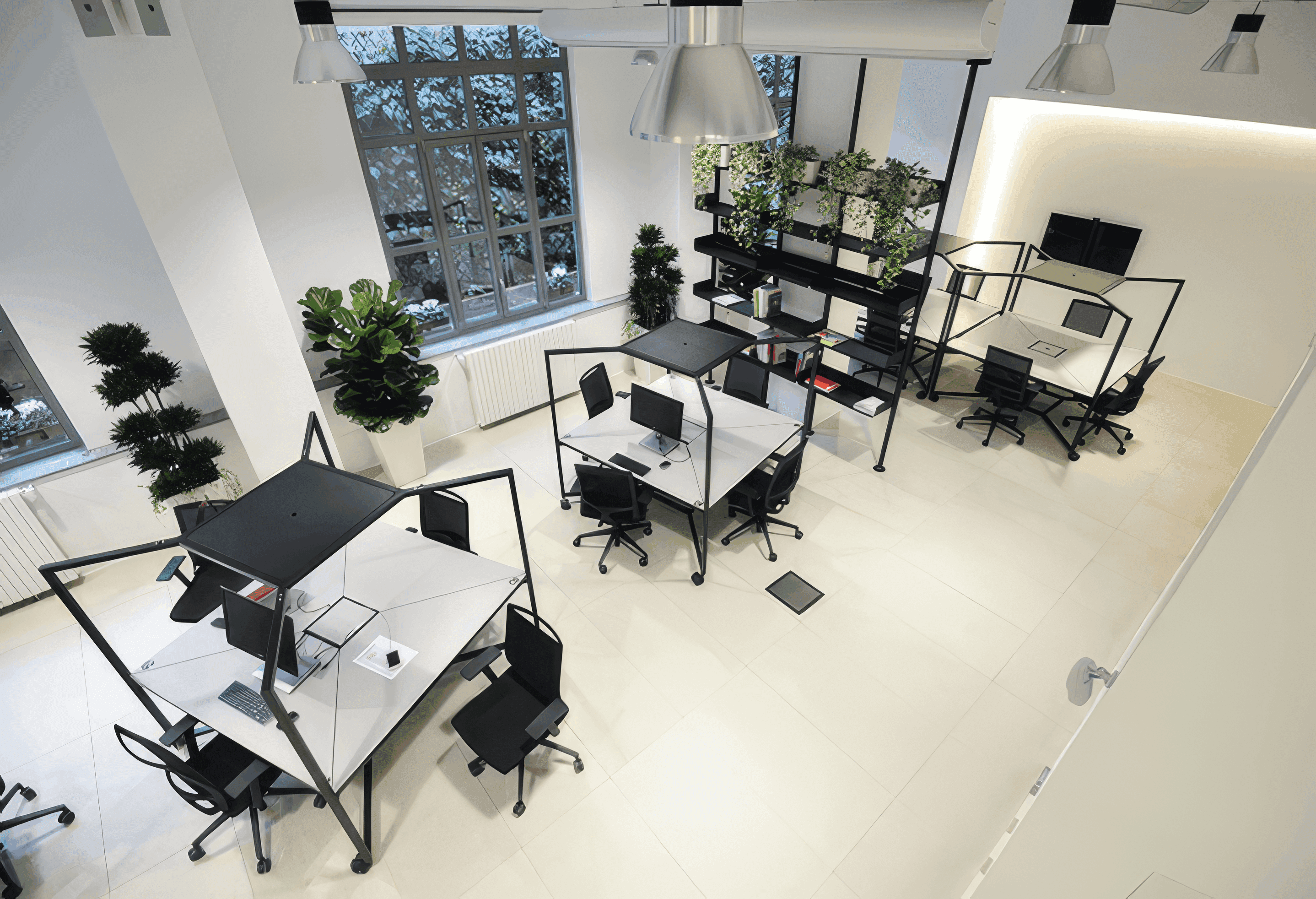 MW Interior  - Vogelperspektive auf modernes Loft-Büro mit modularen schwarzen Tischsystemen, integrierten Pflanzenregalen und weißem Fliesenboden" Beschreibung: Draufsicht auf eine durchdachte Bürolandschaft mit modularen Arbeitsinseln, einem begrünten Regaltrennersystem und klarer Schwarz-Weiß-Ästhetik – Funktionalität und Natur als gestalterische Einheit.