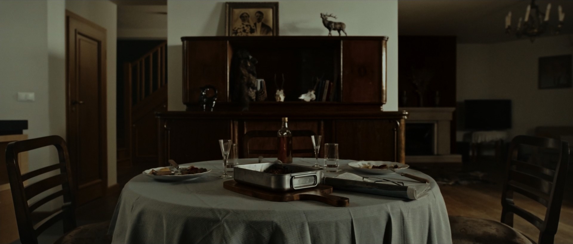 Still life shot of a dinner table with vodka and food, atmospheric set design.