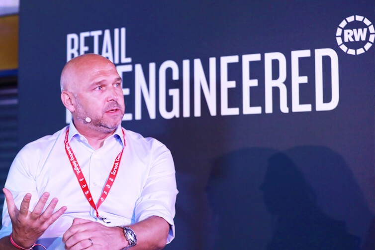 Speaker at Retail Week event with 'Retail Re-engineered' backdrop