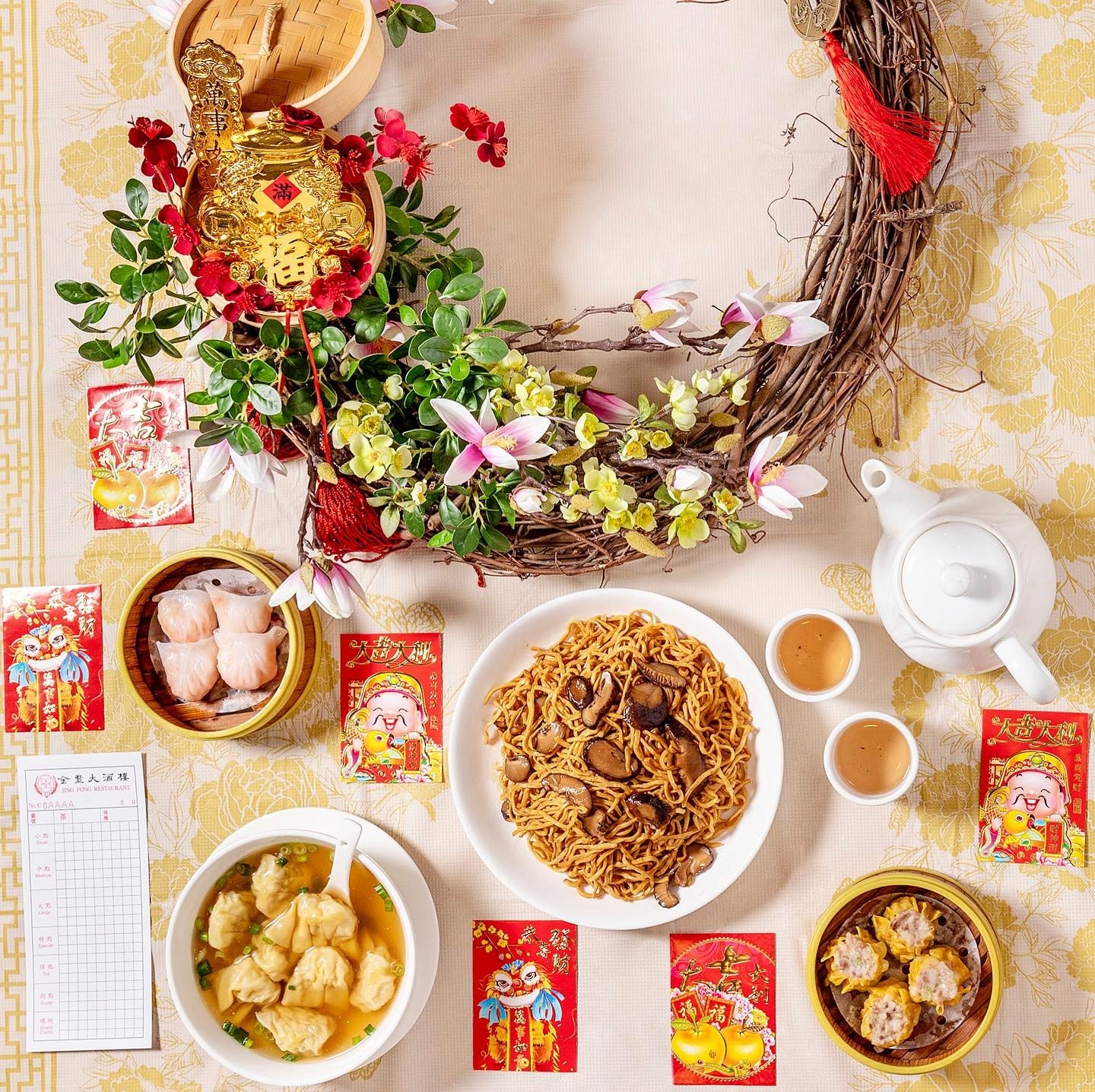 A vibrant spread of traditional dim sum dishes at Jing Fong, including BBQ pork buns, rice noodle rolls, shumai, and egg tarts, served on elegant white plates in their Chinatown location.