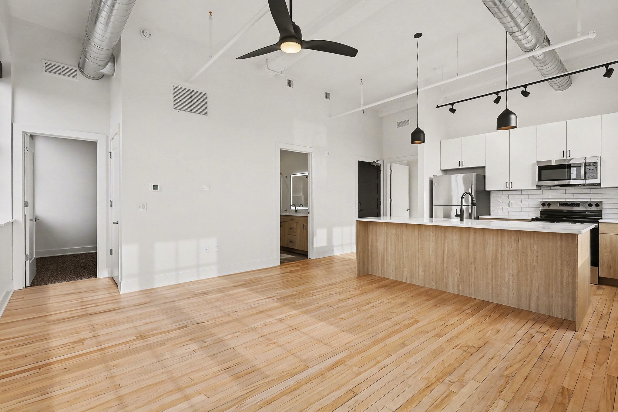 A modern kitchen featuring a bar stool beside a sleek refrigerator, showcasing a clean and organized space.