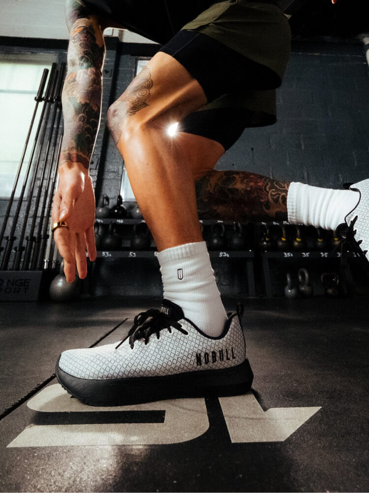 Two toddlers in puffy jackets playing in the snow.