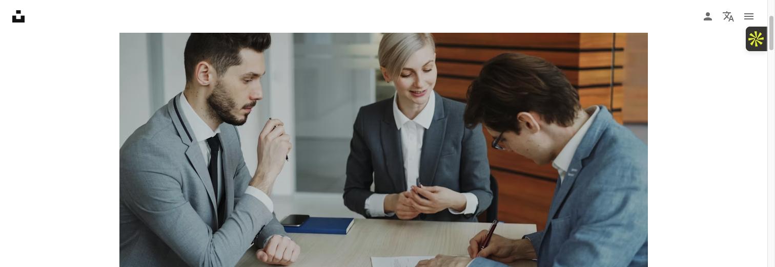 Business professionals reviewing and signing legal documents at a conference table