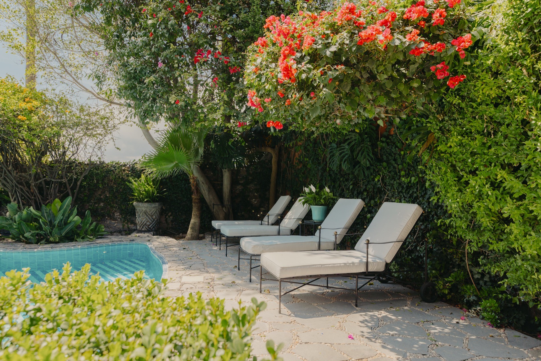 La Residencia San Miguel sculpted garden hedges with pool and stone sculptures beyond