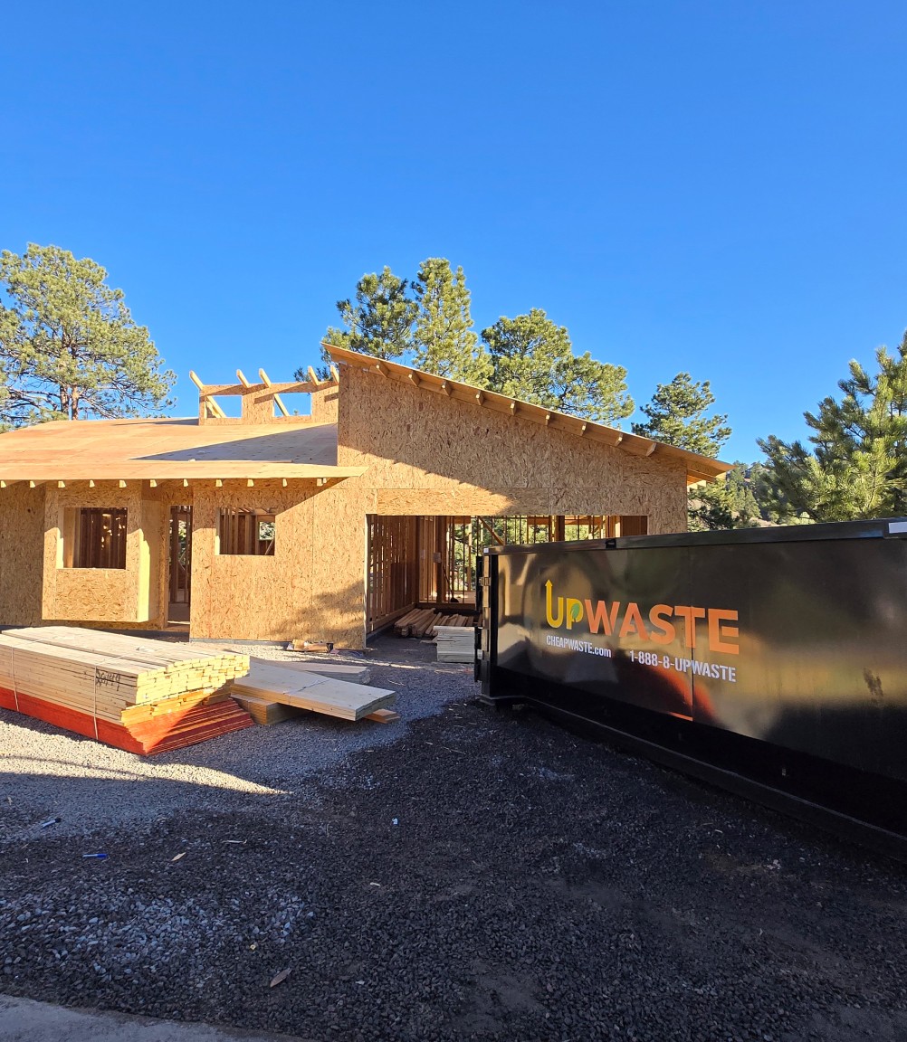large UpWaste dumpster on the pavement walkway of a residential area