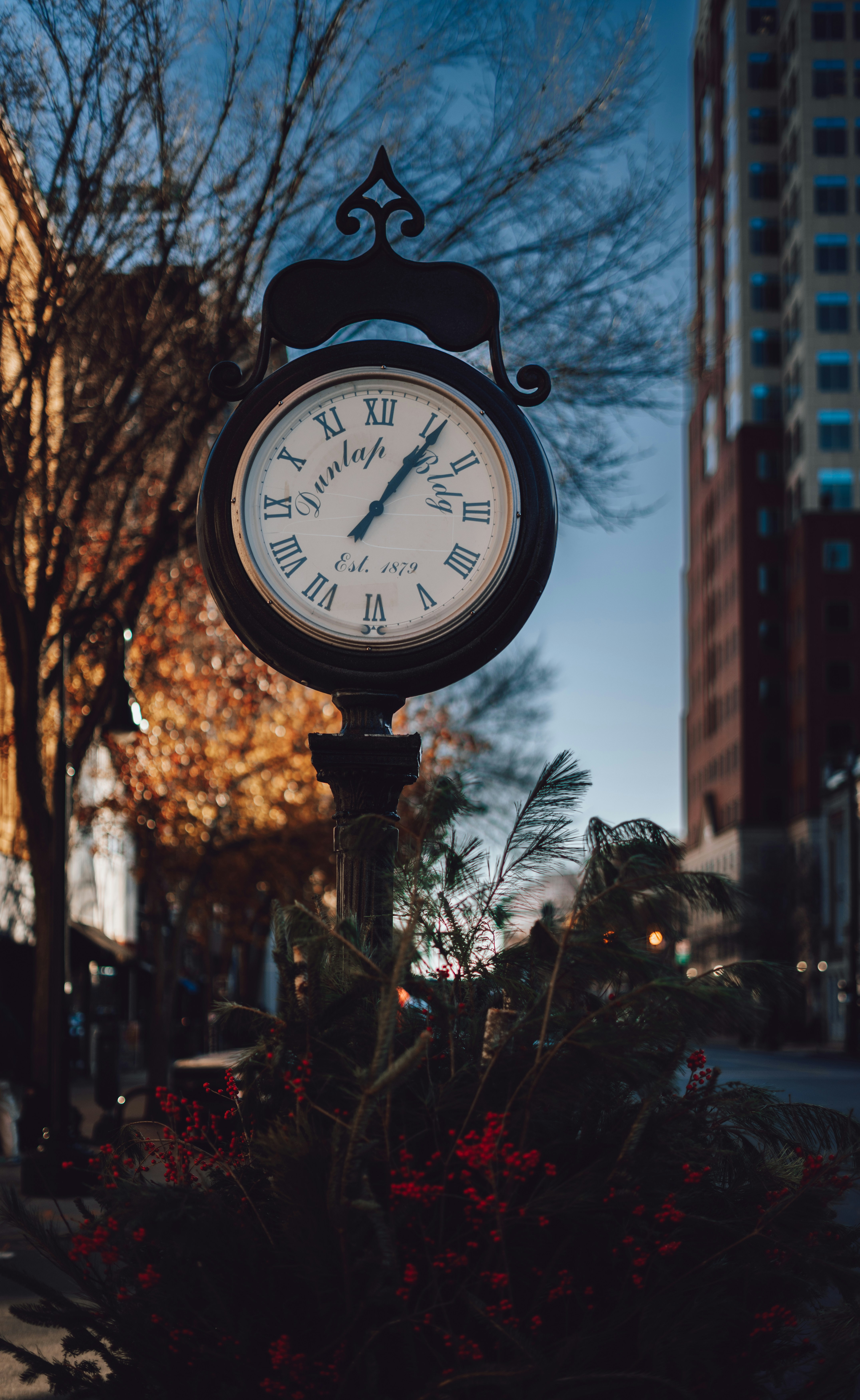 A clock on a pole in the middle of a street