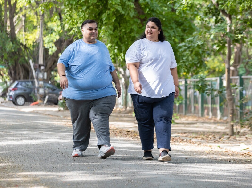 plus-sized couple doing their steps per day for weight loss with a short walk outside