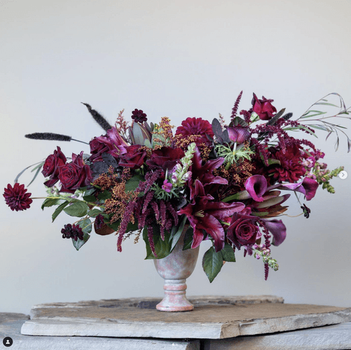 A table with plates , glasses , and flowers on it.