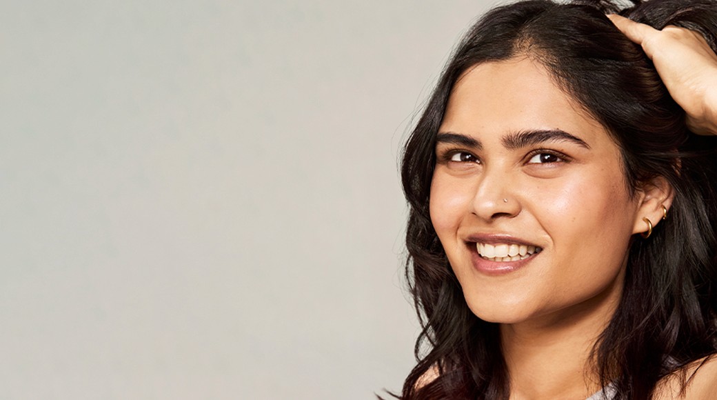 Woman with brown curly hair smiling