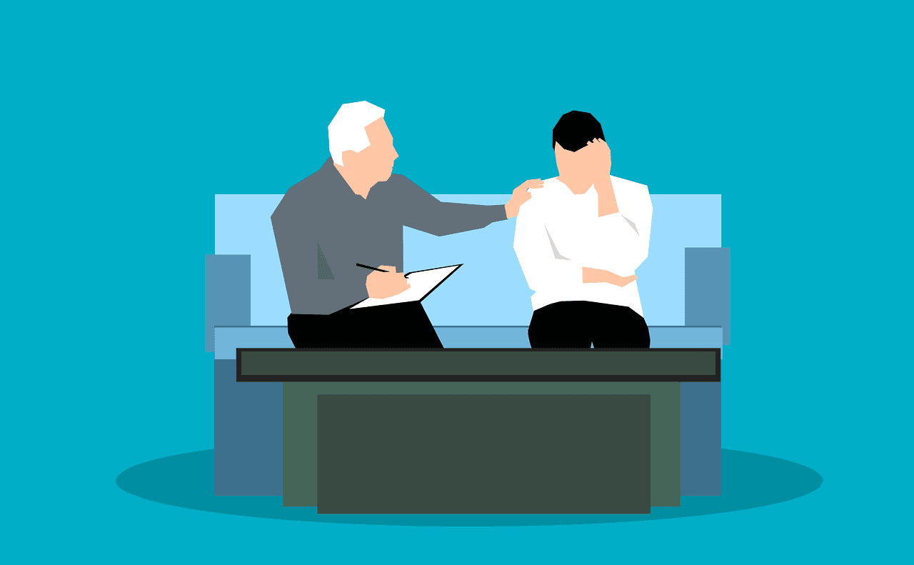 Two people sat on a sofa, one comforting the other