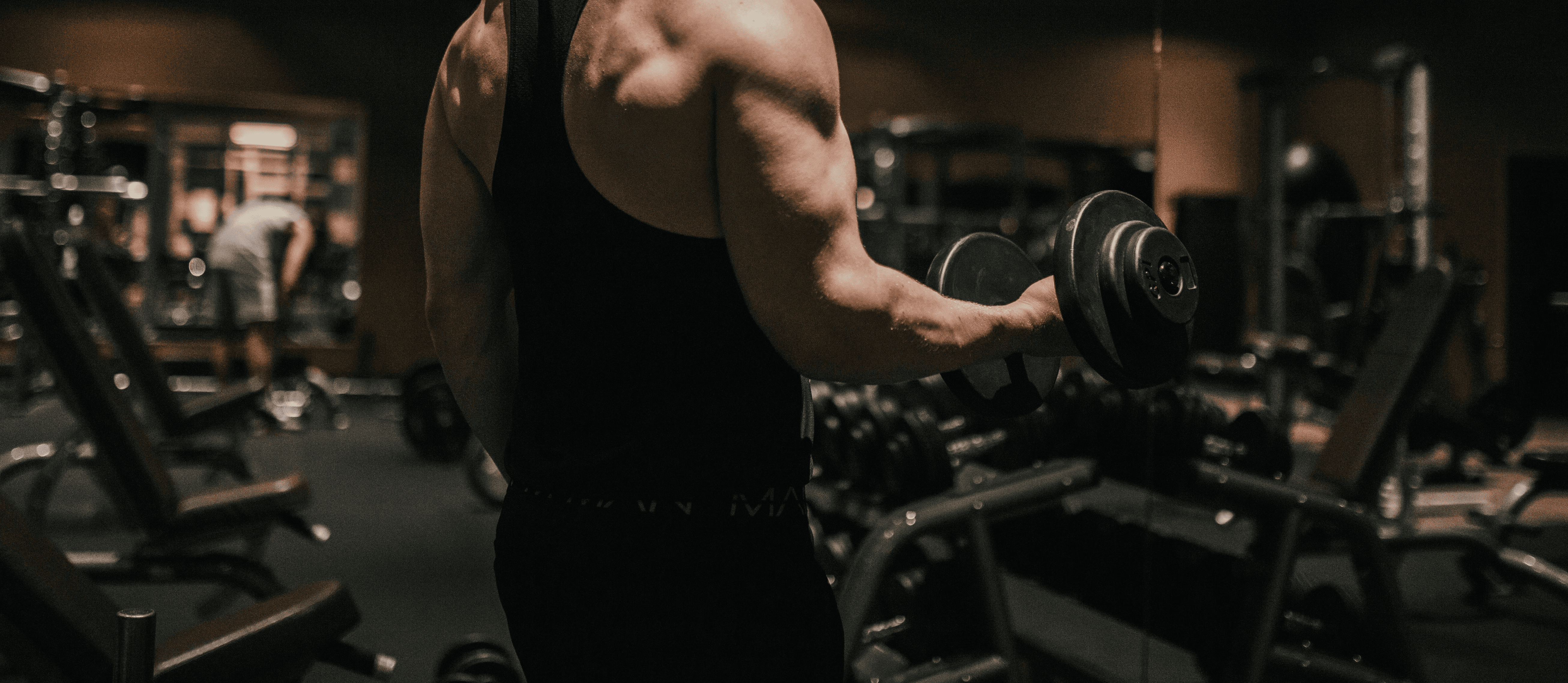 a man holding a dumbbell in a gym